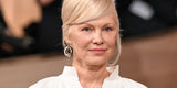 Pamela Anderson with sleek white-blonde hair styled in a glossy French twist