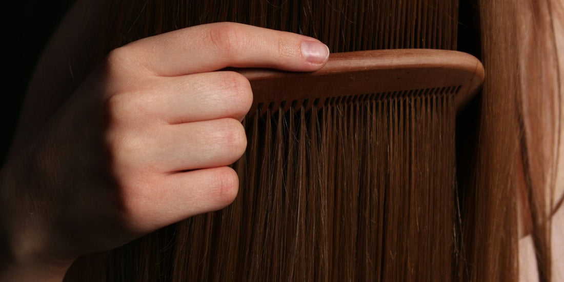 Woman examining her hair length in the mirror, focusing on slow hair growth
