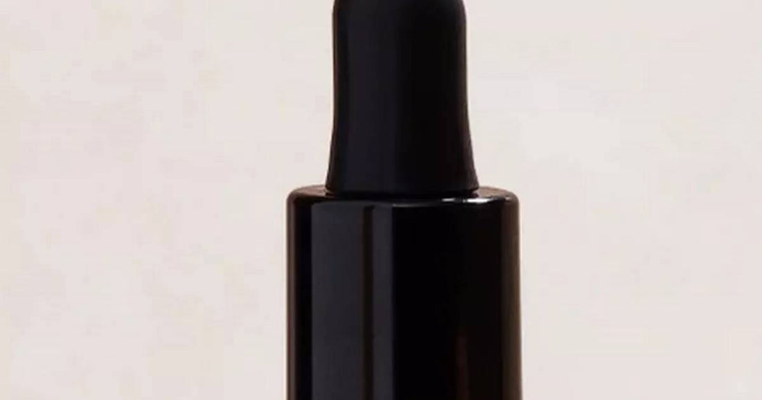Dropper bottle of hair oil/serum photographed for a beauty feature