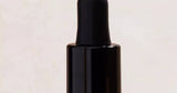 Dropper bottle of hair oil/serum photographed for a beauty feature