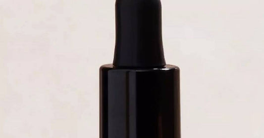 Dropper bottle of hair oil/serum photographed for a beauty feature