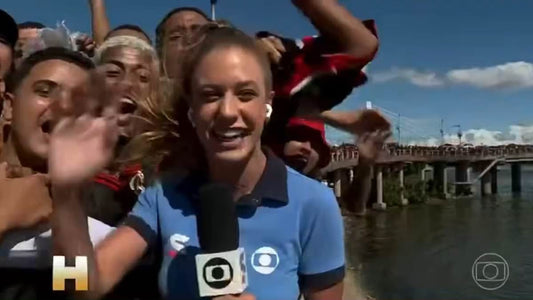 Sports reporter surrounded by football fans as one pulls her hair