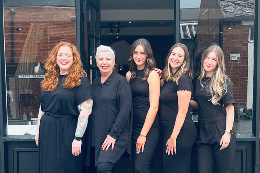 Salon interior with styling stations, mirrors and warm lighting