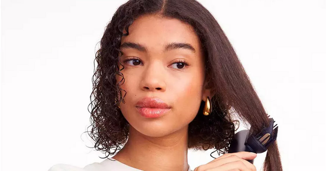 Close-up of a woman using a root-lifting hot brush for smooth volume