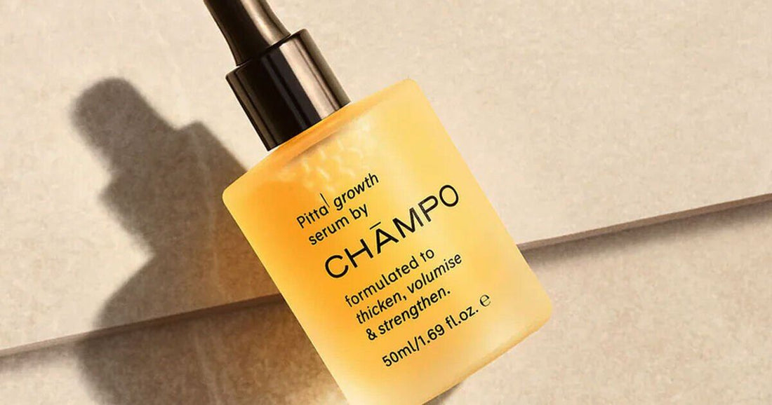 Dropper bottle of hair serum beside glossy hair strands