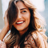 Hair being styled with heat tools, representing common hair habits to avoid