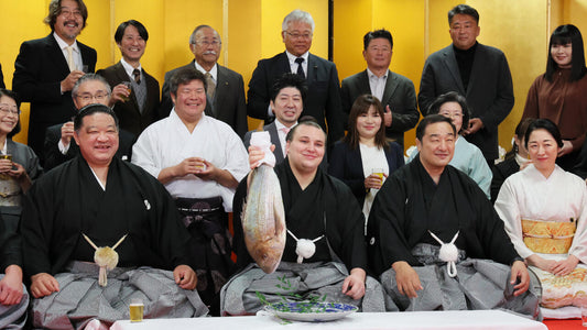 Ukrainian sumo wrestler Danylo Yavhusishyn holds a sea bream after promotion ceremony