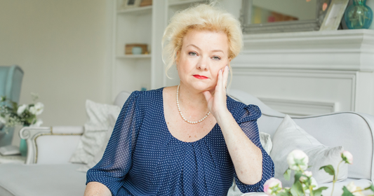 Confident woman over 60 with a modern, softly layered hairstyle and natural grey blending