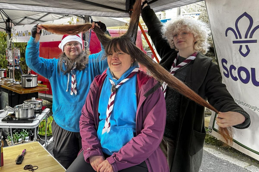 Gemma having her long hair cut to raise funds for Mealbank House, with supporters nearby