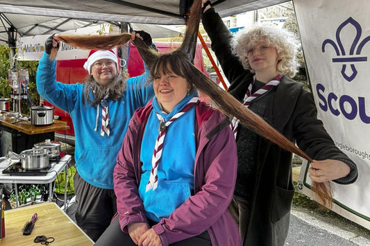 Gemma having her long hair cut to raise funds for Mealbank House, with supporters nearby