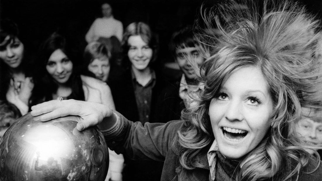 Close-up of a woman smoothing winter hair—illustrating static flyaways and hair care