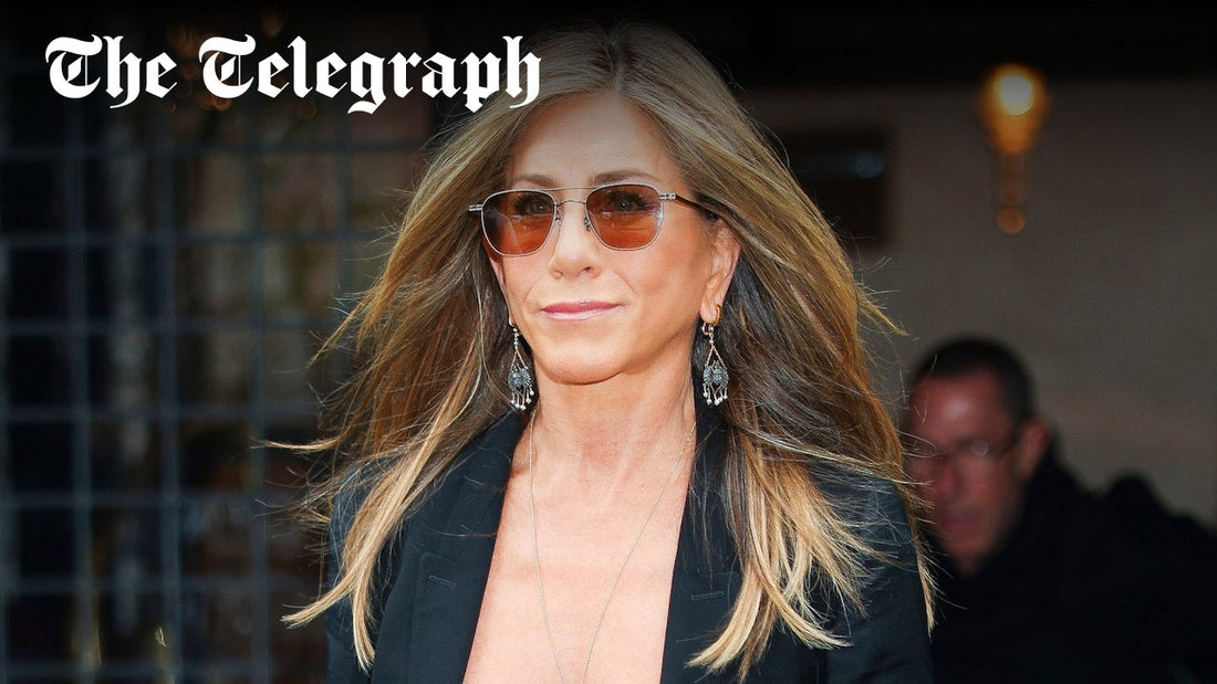 Jennifer Aniston with softly blended grey highlights and textured mid-length hair