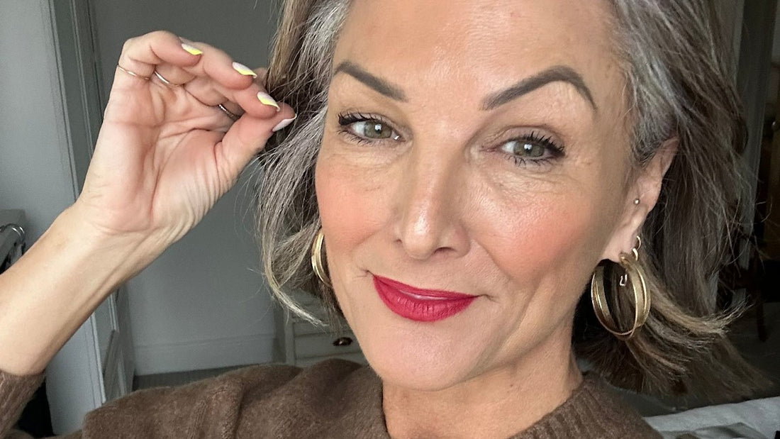 Smiling woman with grey hair wearing soft, flattering makeup