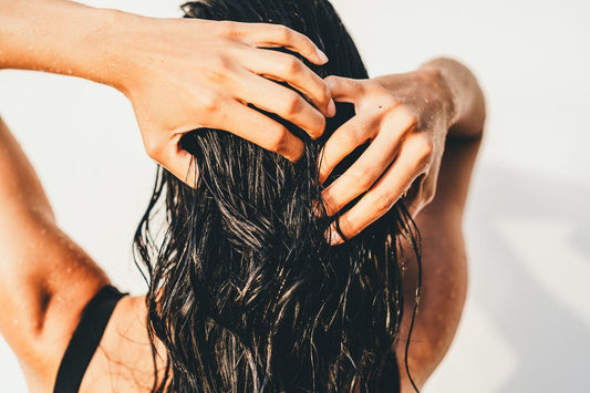Woman examining thinning hair at the scalp in natural light