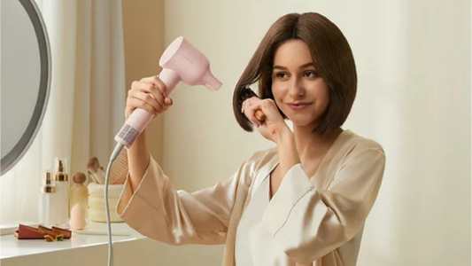 A compact, lightweight hair dryer pictured in a bright studio-style hero image