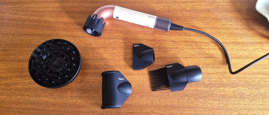 Dyson Supersonic r hair dryer on a marble surface, close-up of nozzle and controls