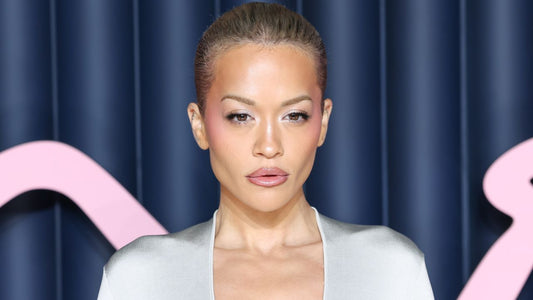 Rita Ora with a sculpted soft-serve ice cream inspired updo and face-framing tendrils